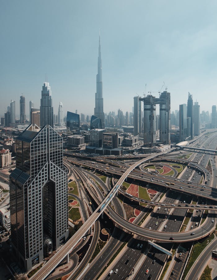Stunning aerial shot of Dubai's skyline with iconic skyscrapers and highway interchanges.